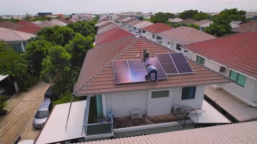 Drone view of engineer worker installed solar panels on roof of house.