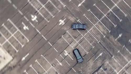 Aerial view of driver drifting on sport car making circles on empty parking