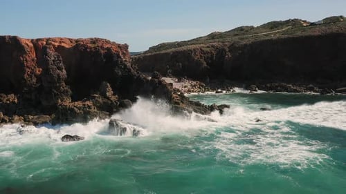 Majestic View of Large Ocean Waves Crashing Against Rocky Shore