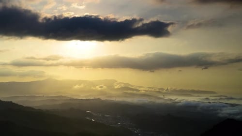 Über den kaskadierenden Bergen gibt es dämmerungsförmiges Licht und dynamische Wolken.