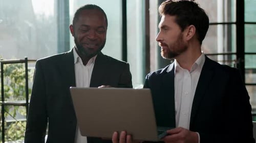 Businessmen Discussing Project on Laptop in Modern Office