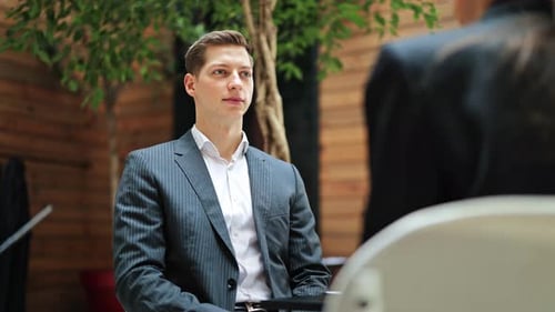 Businessman and Businesswoman Shaking Hands in Modern Office After Successful Deal