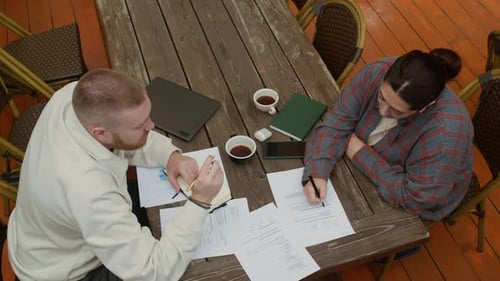 Colleagues working together at wooden table outdoors