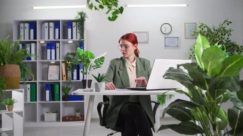 Woman Taking Pills at Desk in Modern Office