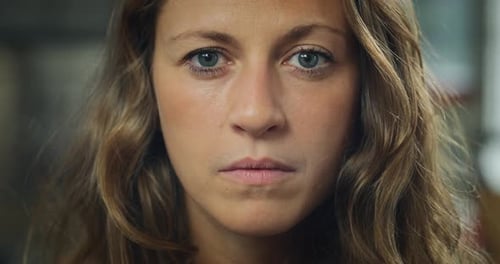 Authentic close up shot of an young attractive happy woman is smiling in camera in a living room a