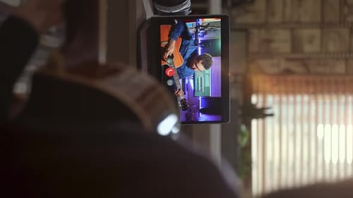 Man Plays Guitar in Video Call on Laptop