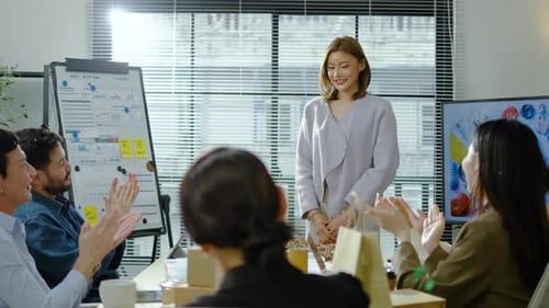 Corporate Team Applauds Woman's Presentation in Meeting Room