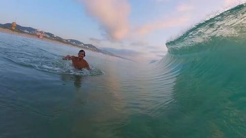 Man Wades in Ocean, Wave Crashing Over Camera