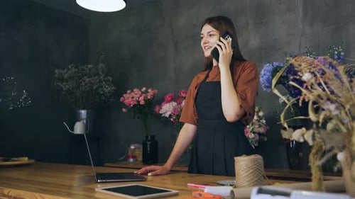 The Seller the Owner of a Flower Shop Talks to the Customer on the Phone and Calculates the Cost of