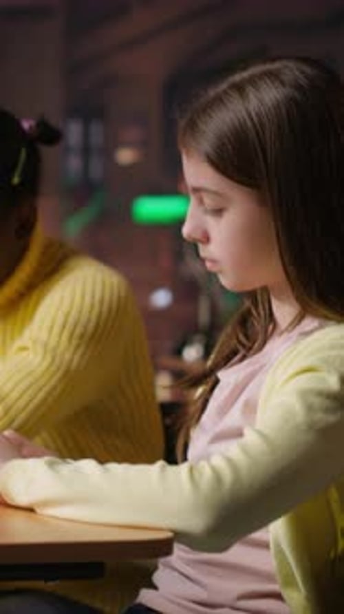 Vertical Video Teen Girls Reading Books in the Library to Focus on Mandatory Literature