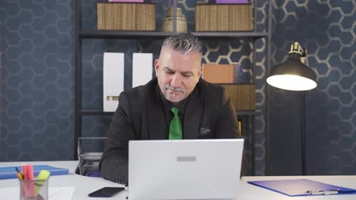 Man in Business Suit Typing on Laptop Computer