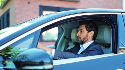 Confident Businessman Driving a Modern Car Smiling Happily on Sunny Day Journey