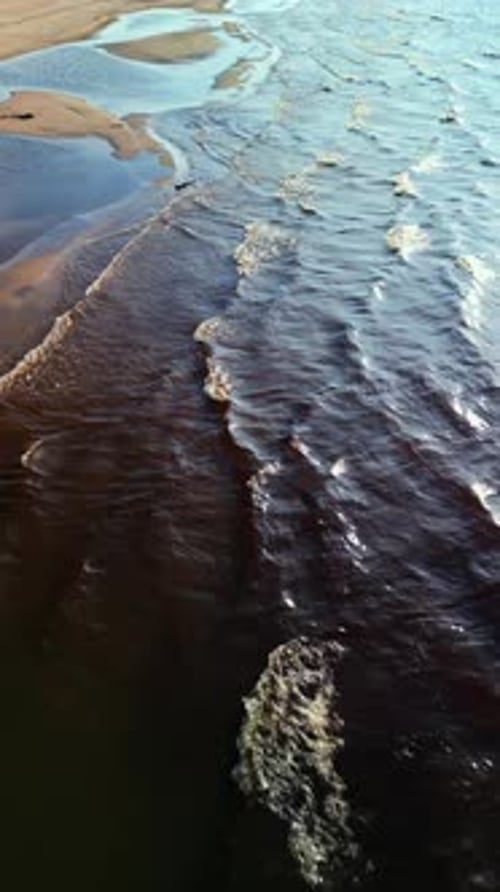 Relax While Admiring the Serene Coastal View in Realtime Aerial Footage with Waves Meeting the Sandy