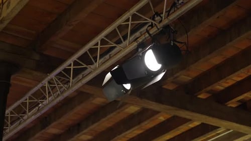 Stage lights on truss at a rustic wooden venue
