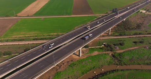 Tagesverkehr auf einer Landbrücke, umgeben von üppiger grüner Landschaft