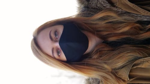 Blond Woman Wearing Face Mask Looking at Camera