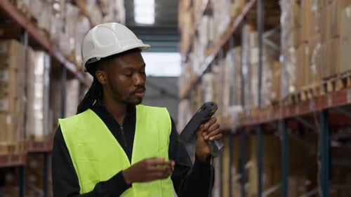 Warehouse Worker Scanning Inventory in Logistic Center Aisle