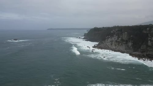 Aerial Drone Shot of Sea Waves Breaking on Rocky Mountains