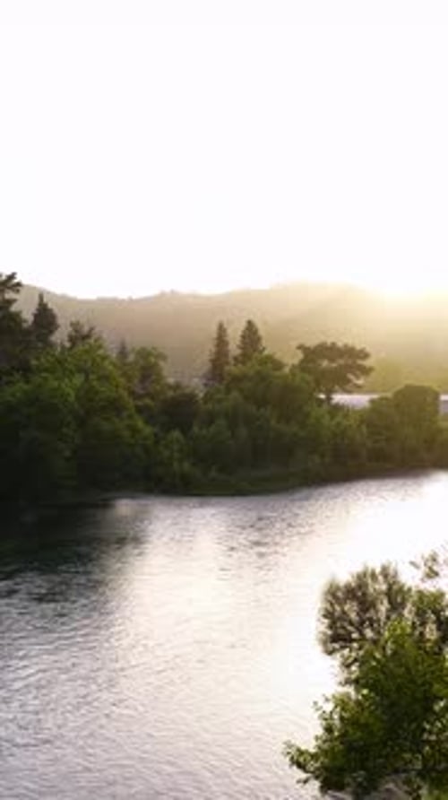 Vertical Video Aerial Natural Valley with River Flow and Sunset Reflection