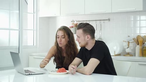 Young Adults Relaxing with Laptop and Eating Fruit