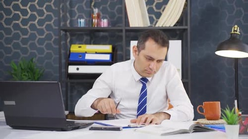 Man Writing at Office Desk in Corporate Setting