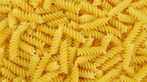 Close up of uncooked yellow rotini pasta