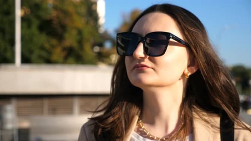 Young Woman Walking in the City With Sunglasses