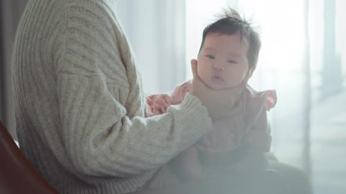 Mother Holds Infant in a Warm, Natural Light
