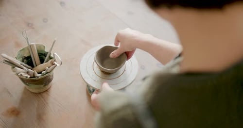 Female Artist Crafting in Pottery studio using Hands and Clay