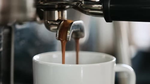 Espresso Pouring From Machine Into White Mug
