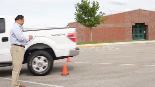Driving instructor congratulates student after passing driving test