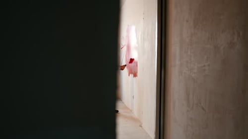 Boy and man painting wall red in home