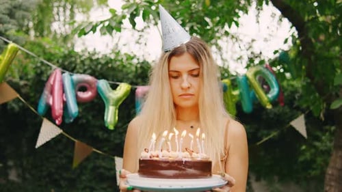 Blonde Woman Holding Birthday Cake Outside
