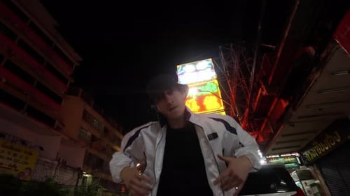 Young Man Dancing in City at Night