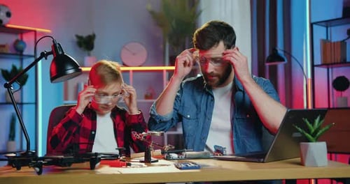 Father and Child Soldering Circuit Board Together