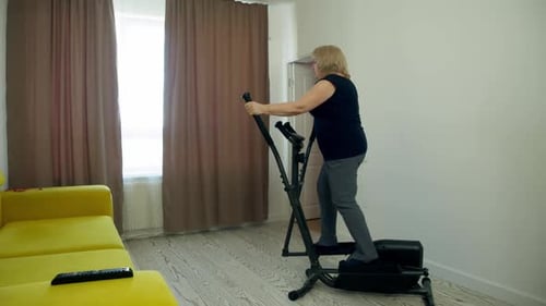 Woman Exercising on Elliptical Machine at Home