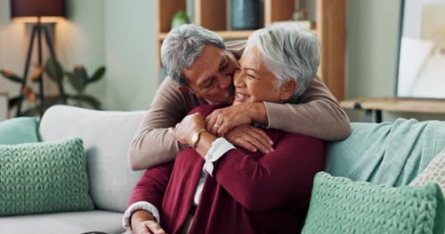 Affectionate Senior Couple Embracing on Couch at Home