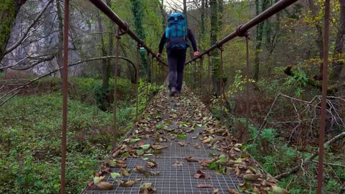 man backpaking on the rope suspension bridge