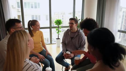 Diverse group of people sitting in circle in group therapy session.Diverse group of people sitting i