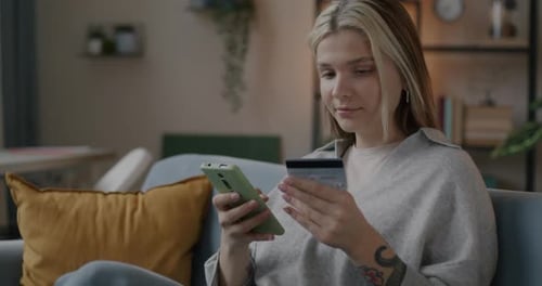 Slow Motion of Happy Girl Shopaholic Making Payment in Online Store Using Smartphone and Bank Card