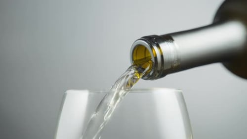 Vin blanc sortant d'une bouteille