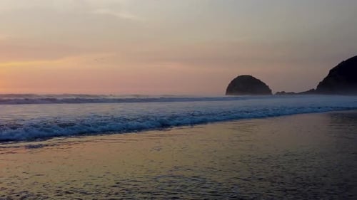 sandy beach of south amercia. sunset at ocean with rock cliffs at the back
