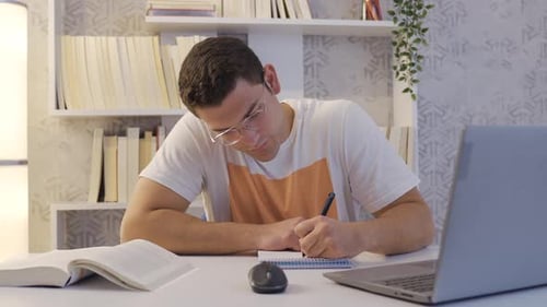 Working college student focused on his lesson.