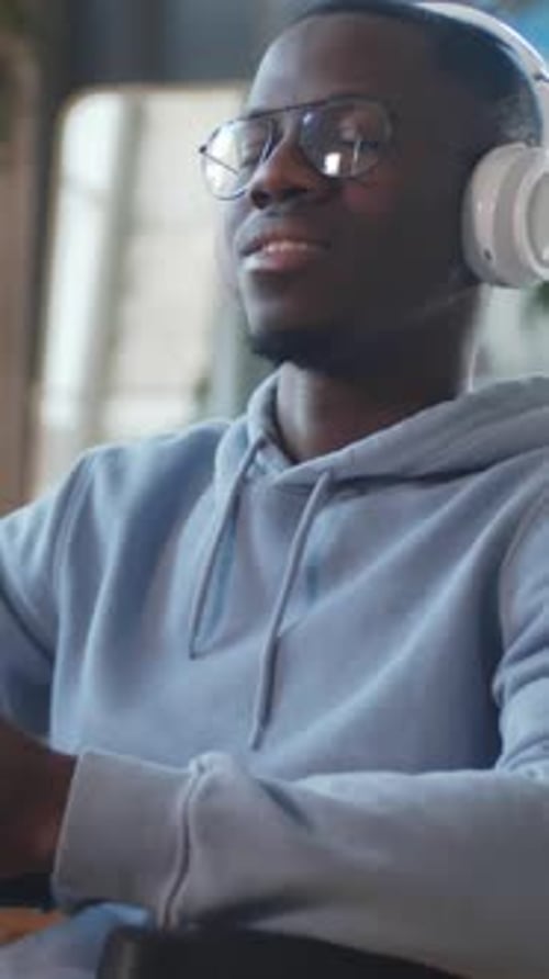 Man Relaxing with Headphones Listening to Music Indoors