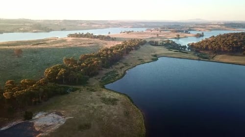 Rising drone footage of dry paddocks and the Upper Coliban reservoir, near Tylden, central Victoria,