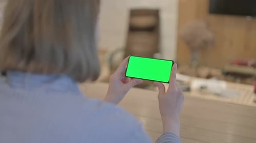 Young Woman Holding Phone with Chroma Key Screen