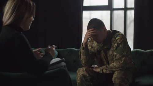 Troubled Man Talking to Therapist in Dark Room