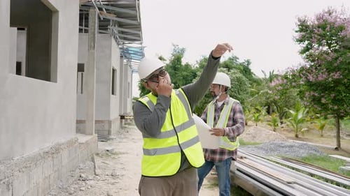 Superviseur de construction asiatique Utilisez une radio sans fil Parlez à un grutier... pour contrôler Grue Man