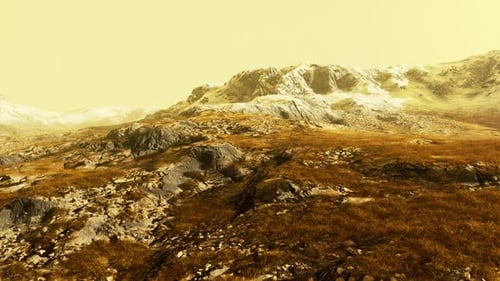 A Snowcovered Mountain Range with a Contrasting Backdrop of Brown Grass