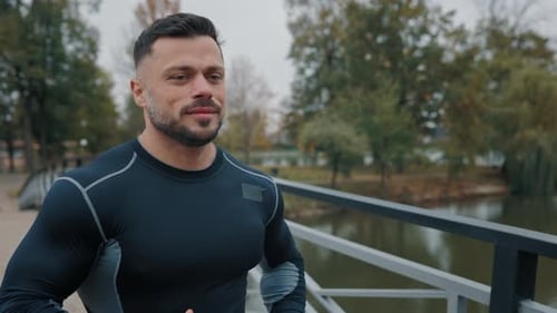 Handsome Guy Athlete Running on Bridge Positive Jogger Training Male Doing Exercises Activities Man